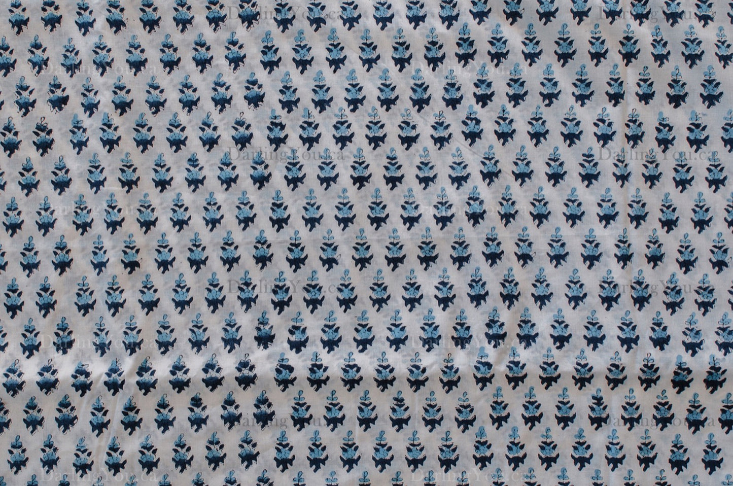 White cotton fabric with two-tone blue floral hand block print, handcrafted in Jaipur, India using traditional woodblock techniques.