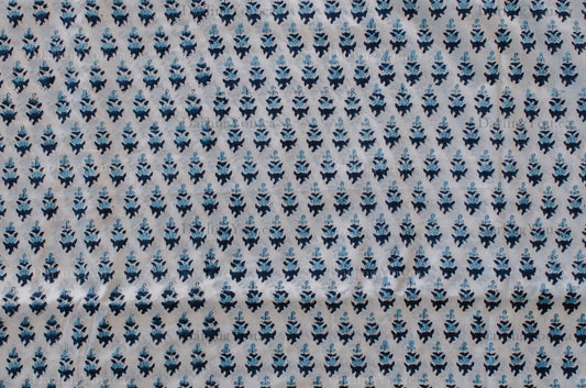 White cotton fabric with two-tone blue floral hand block print, handcrafted in Jaipur, India using traditional woodblock techniques.
