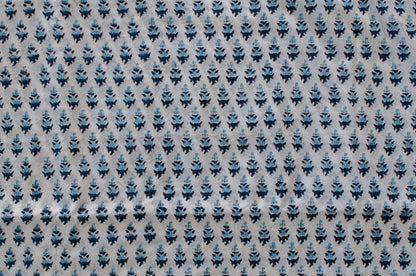 White cotton fabric with two-tone blue floral hand block print, handcrafted in Jaipur, India using traditional woodblock techniques.