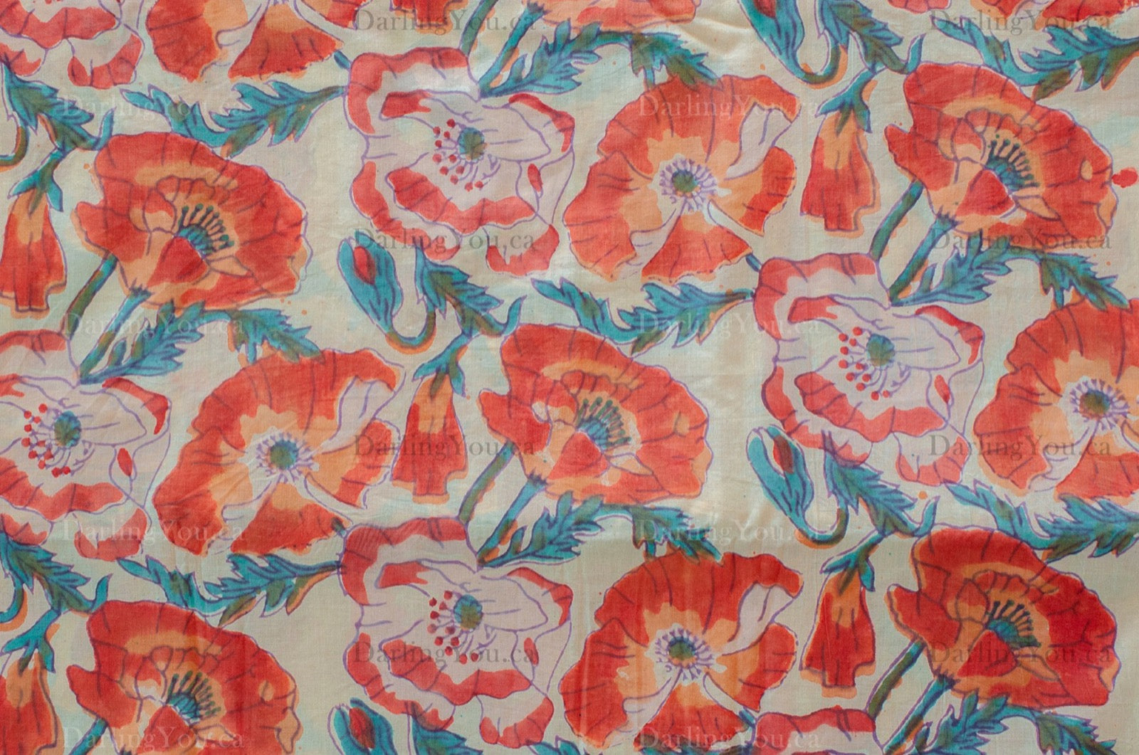White cotton fabric hand block printed with orange, red, and blue floral motifs, handcrafted by artisans in Jaipur, India.