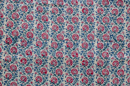 Hand block printed cotton fabric featuring a red, blue, and green floral motif on white, made by artisans in Jaipur, India.