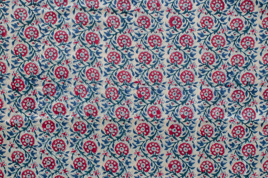 Hand block printed cotton fabric featuring a red, blue, and green floral motif on white, made by artisans in Jaipur, India.