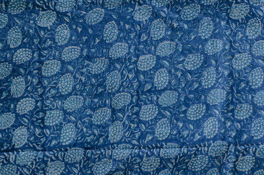 Blue and white cotton fabric with dense floral block print, handcrafted using traditional techniques in Jaipur, India.