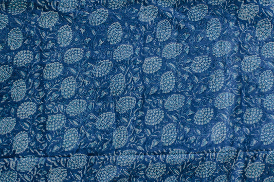 Blue and white cotton fabric with dense floral block print, handcrafted using traditional techniques in Jaipur, India.