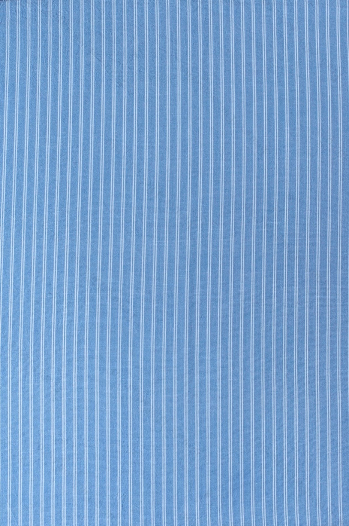 Dark blue organic cotton shirting fabric with clean white yarn-dyed stripe pattern, folded to highlight texture and weave.