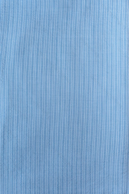 Light blue organic cotton shirting fabric with subtle two-tone blue yarn-dyed stripe pattern, folded to show texture and weave.