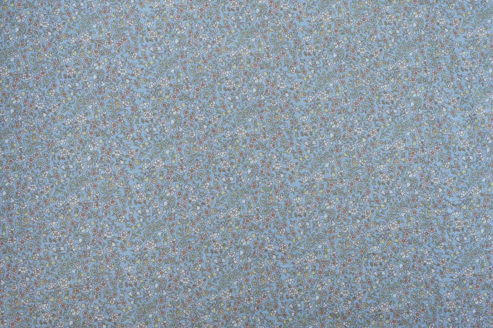 Organic cotton fabric with dense floral print on pale blue background featuring vintage-inspired botanical pattern.
