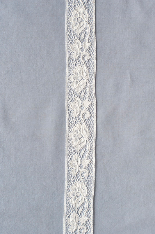 Off-white cotton lace with floral vine embroidery over fine net background, showing intricate leaf and flower detailing.